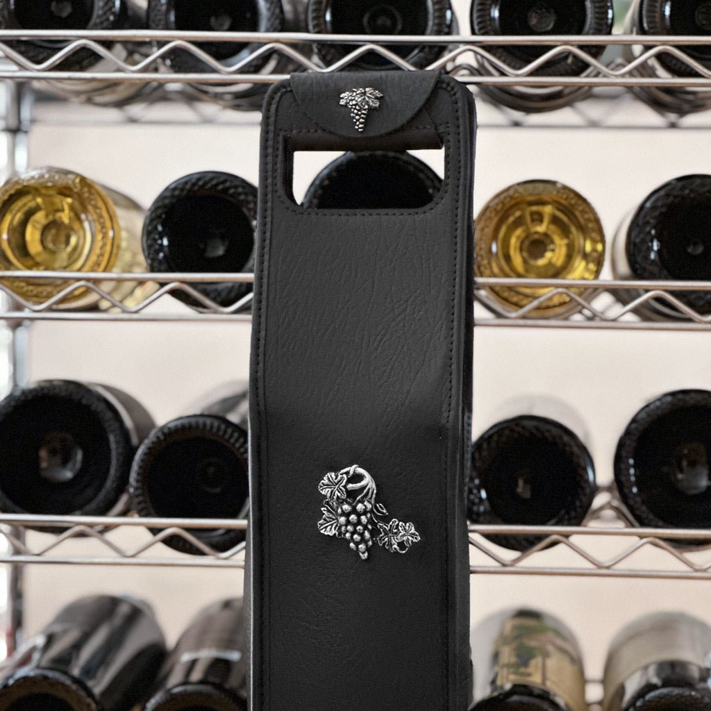 leather wine bottle bag with grape medallion in front of bottle rack