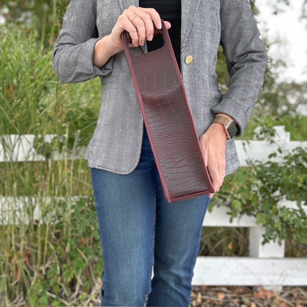 alligator wine bottle bag model in front of white fence